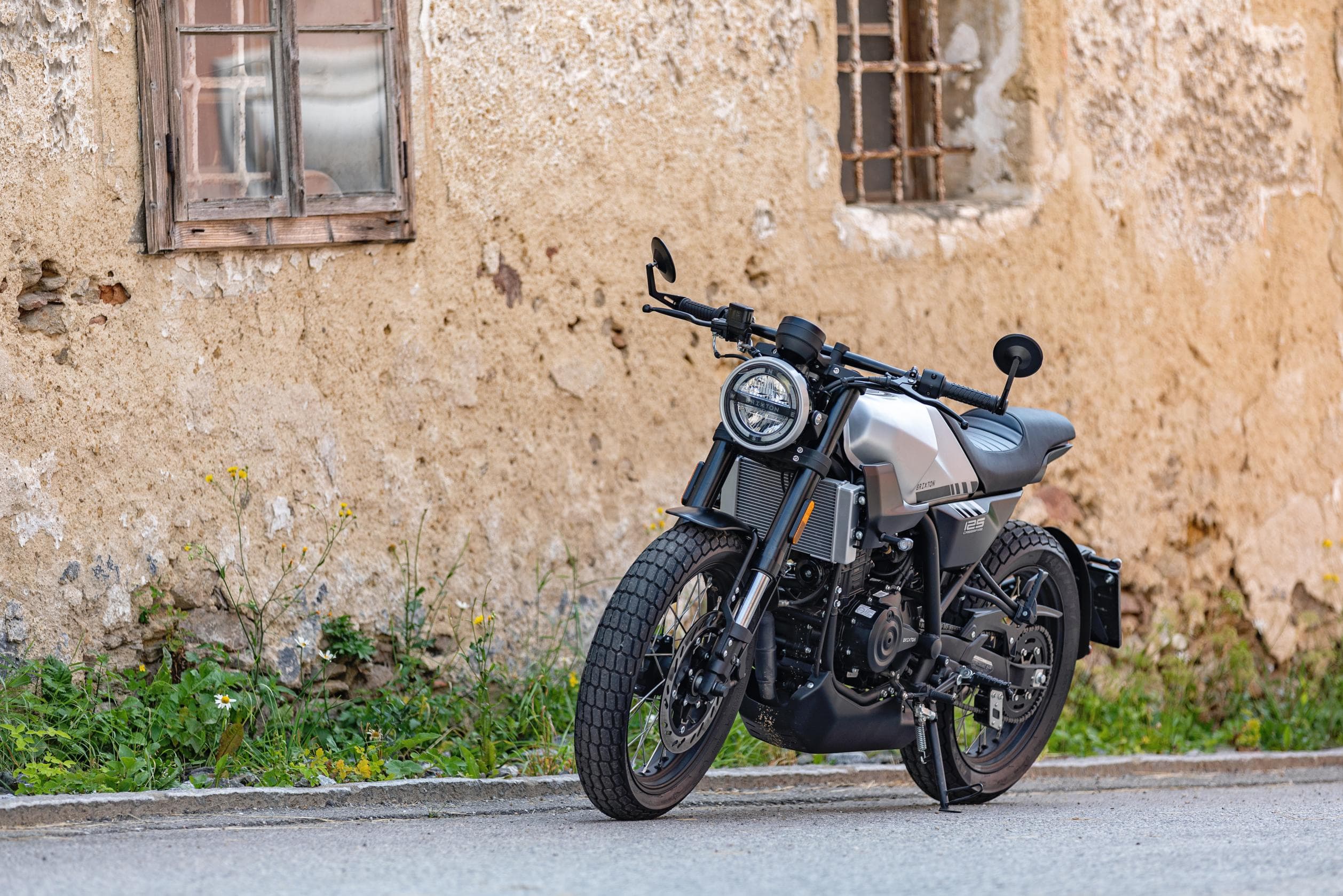 Brixton Crossfire 125 in Bullet Silver parked on the street in front of a derelict building