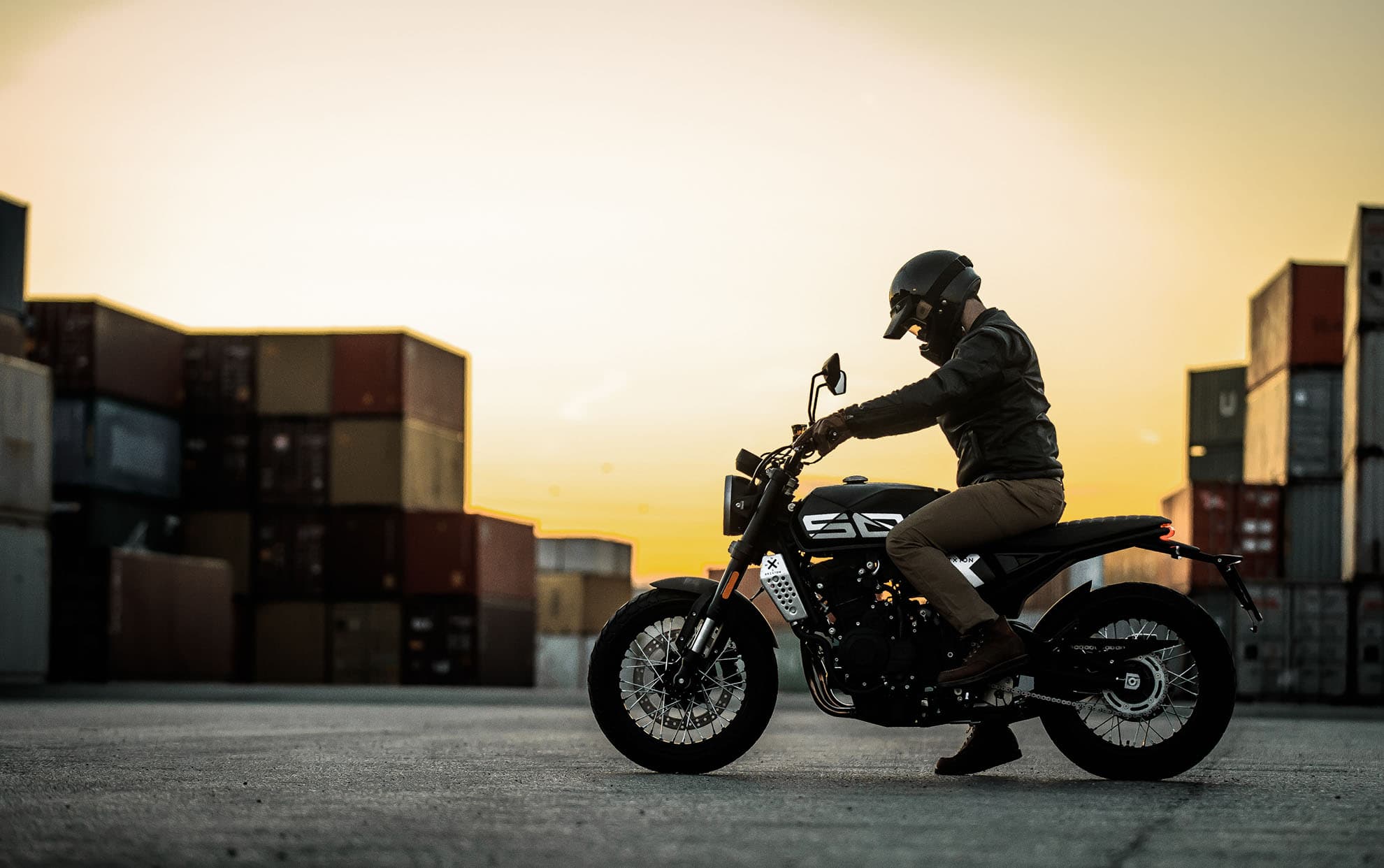 Brixton Crossfire 500 X in Backstage Black in an industrial area at dusk