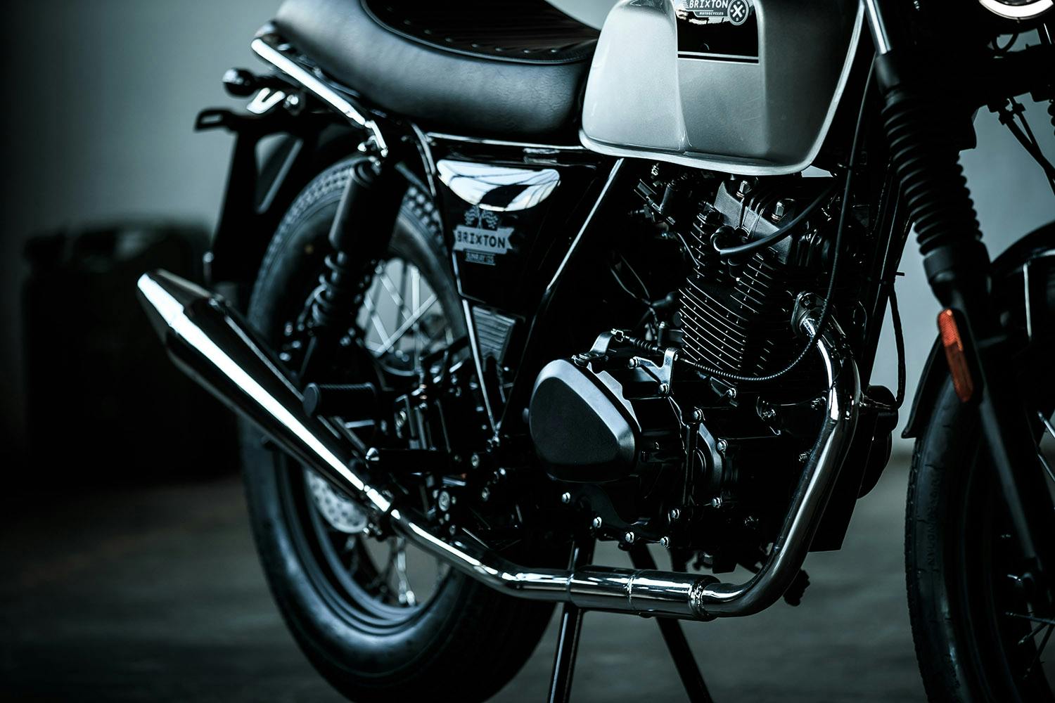 Cropped photo of the motor, exhaust and muffler of the Brixton Sunray 125 in Bullet Silver