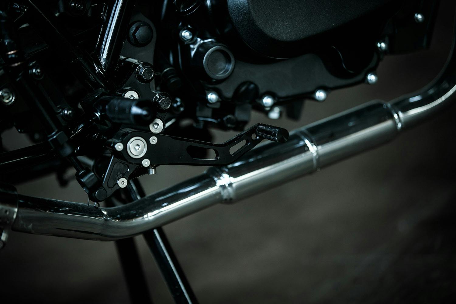 Close-up of the exhaust pipe and footrest of the Brixton Sunray 125 in Bullet Silver