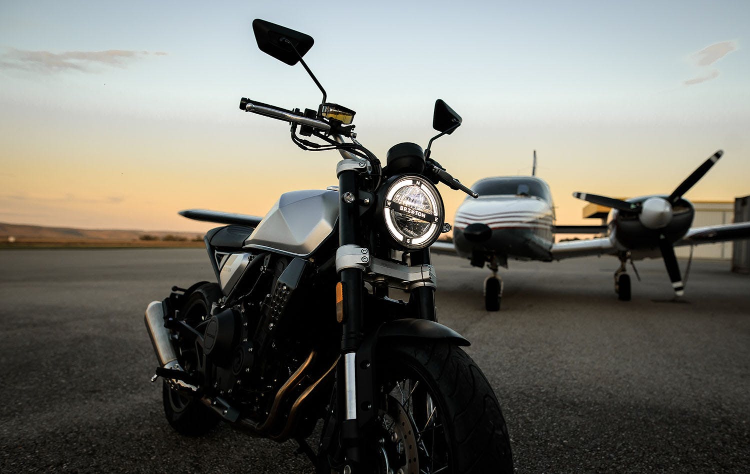 Brixton Crossfire 500 X in Backstage Black on an airfield in front of an aeroplane