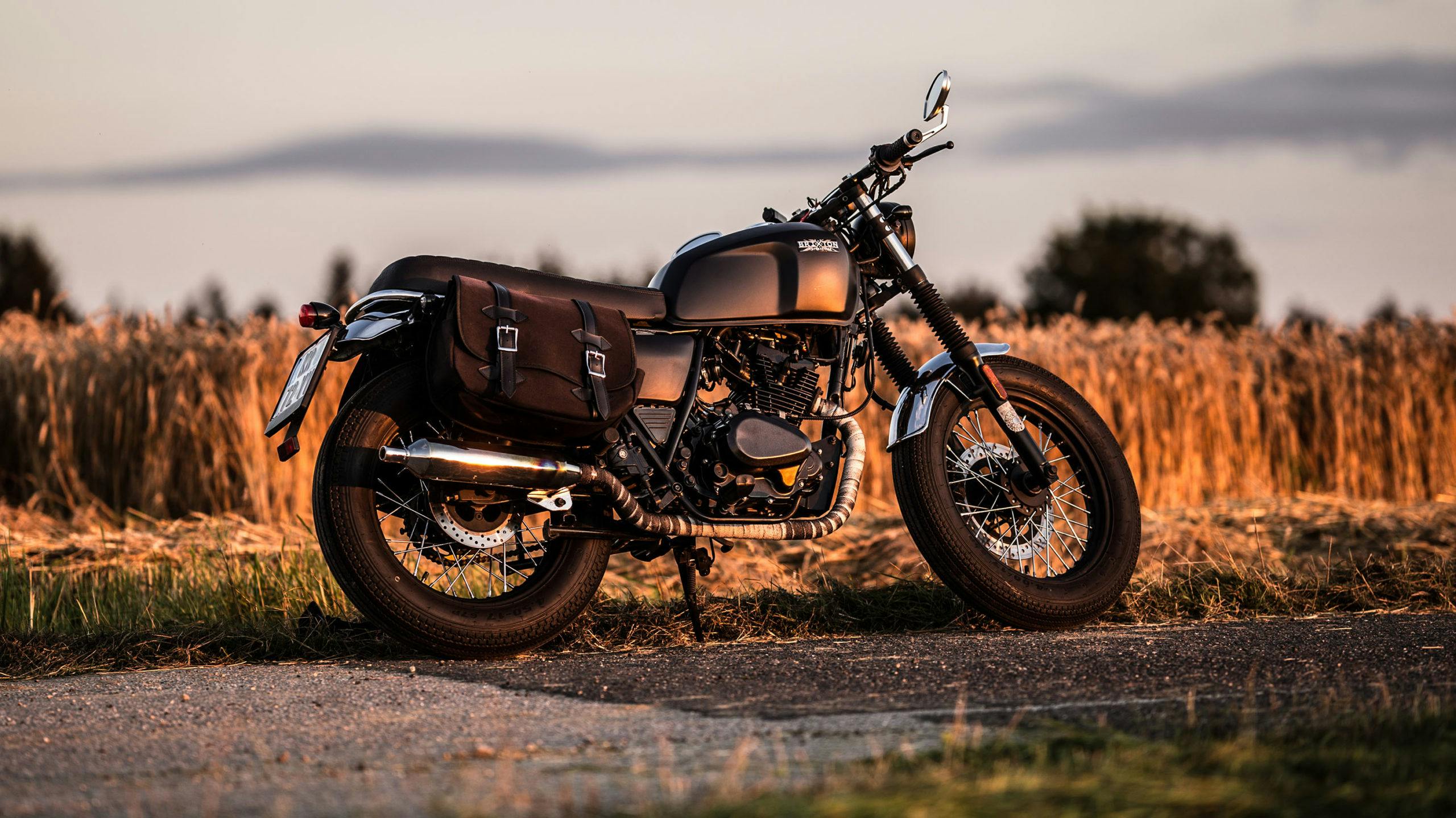 Rider of the Month Robert's Brixton Cromwell 125 in Backstage Black next to a field at sunset