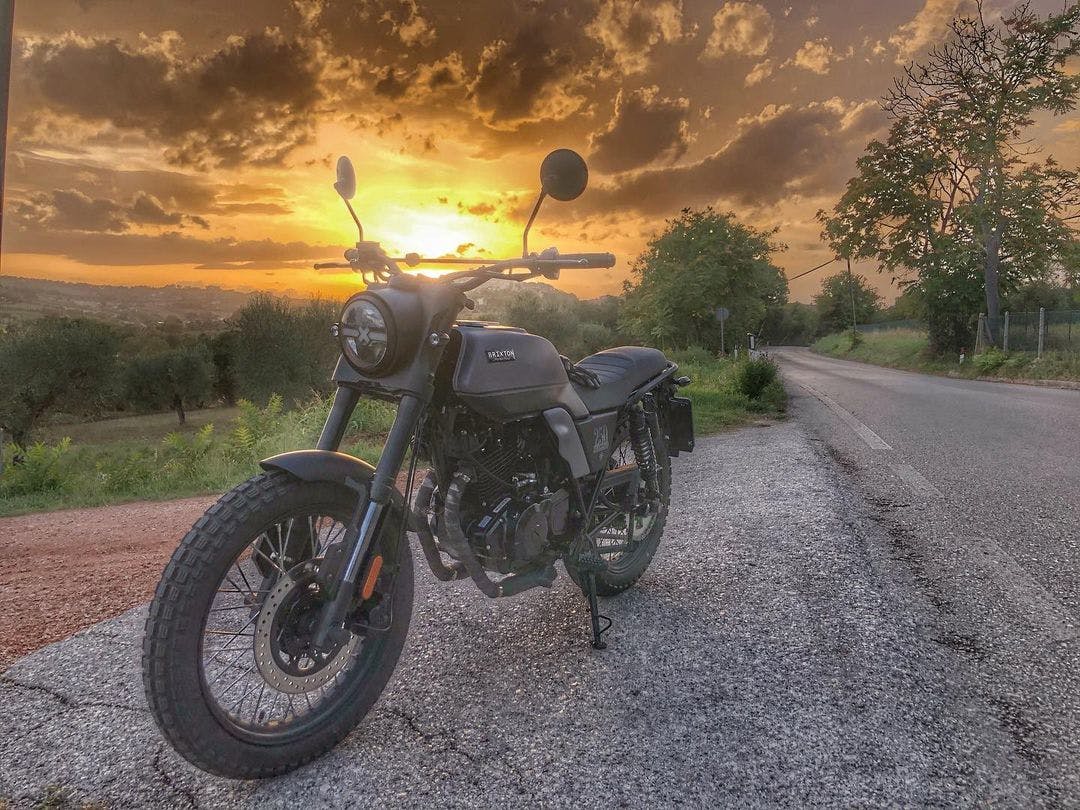Rider of the Month Malgorzata's Brixton Felsberg 250 in Timberwolf Grey parked next to a country road in front of a spectacular sunset 