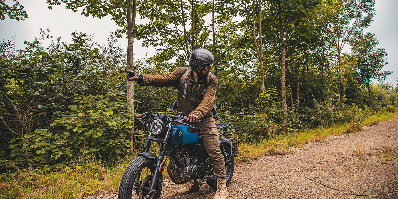 Rider of the Month Kev sitting on his Brixton Rayburn 125 in Royal Blue Matt / Horizon Matt pointing forward while looking back at the road