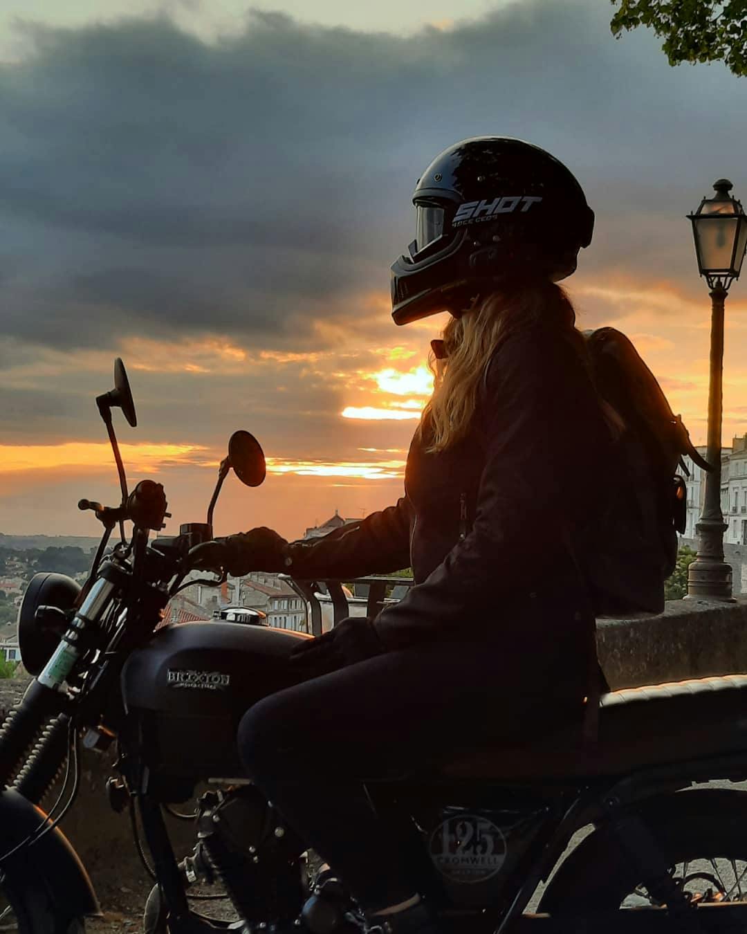 Rider of the Month Joss on her Cromwell 125 in Backstage Black with the sunset in the back