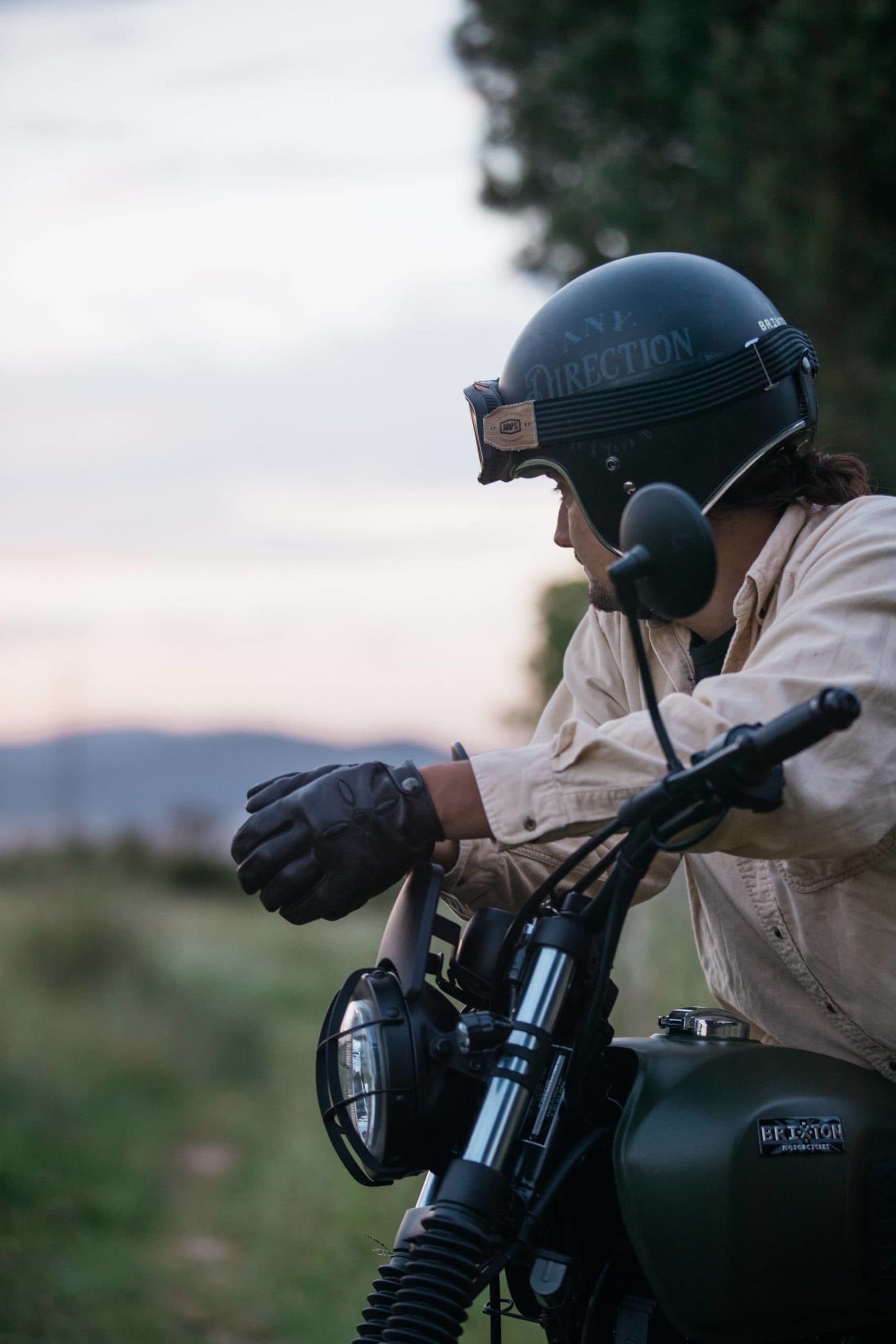 Brixton Motorcycles Felsberg 125 in Cargo Green portrait closeup of a biker sitting atop of the bike looking out into the countryside